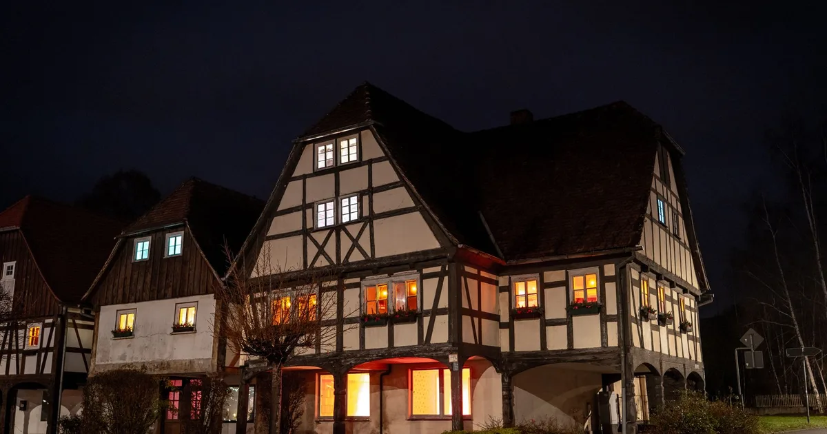 Dom z oświetlonymi oknami nocą, symbol domu i rodziny kojarzonych z liczbą 2121