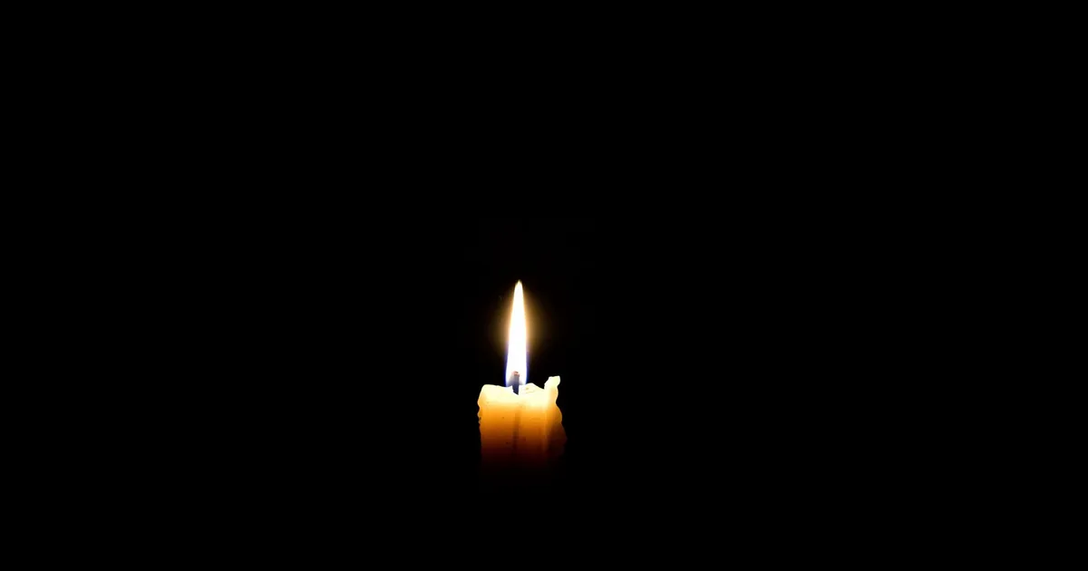 Zapalona świeca w ciemności, symbol refleksji kojarzonej z 999