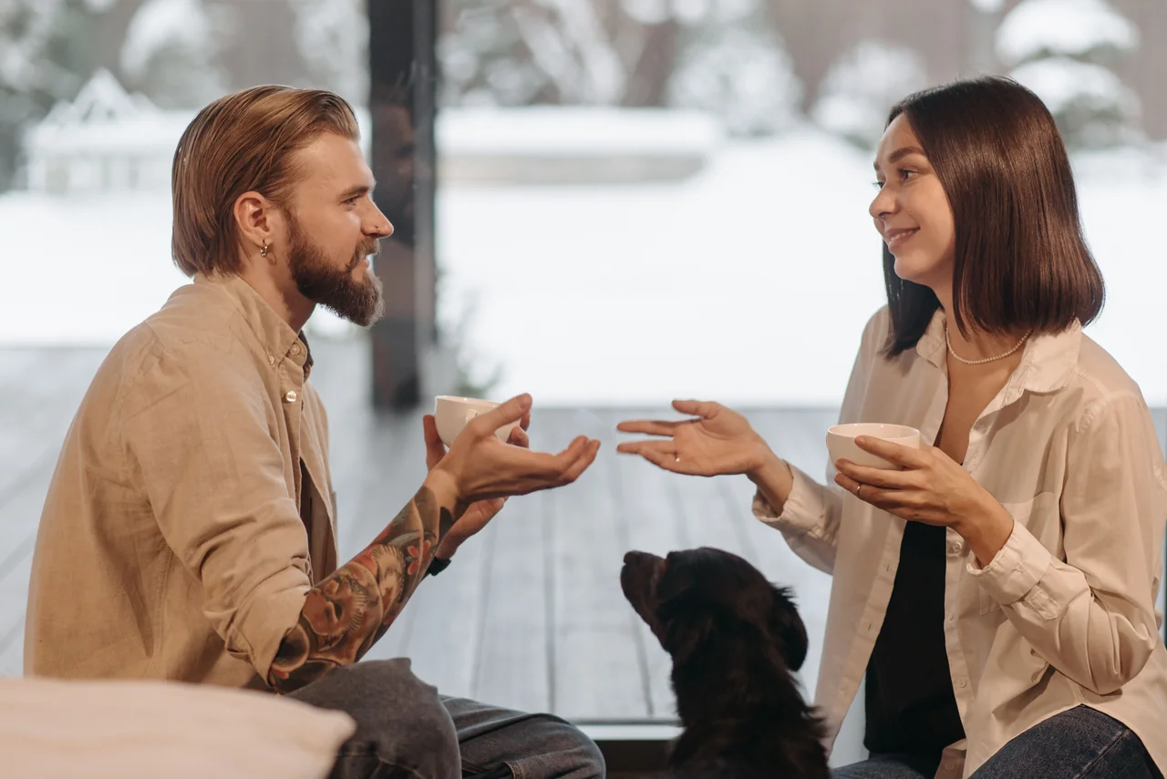 Para rozmawia przy kawie przy oknie – harmonia w relacjach, którą astrologia wiąże z Wagą