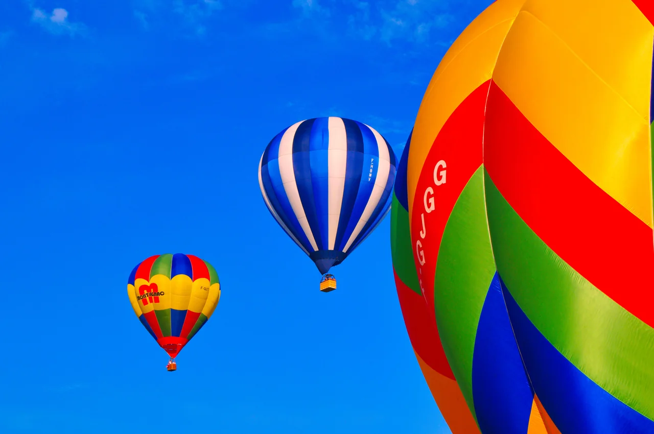 Kolorowe balony na ogrzane powietrze na błękitnym niebie – żywioł powietrza, wspólny dla Wodnika i Wagi