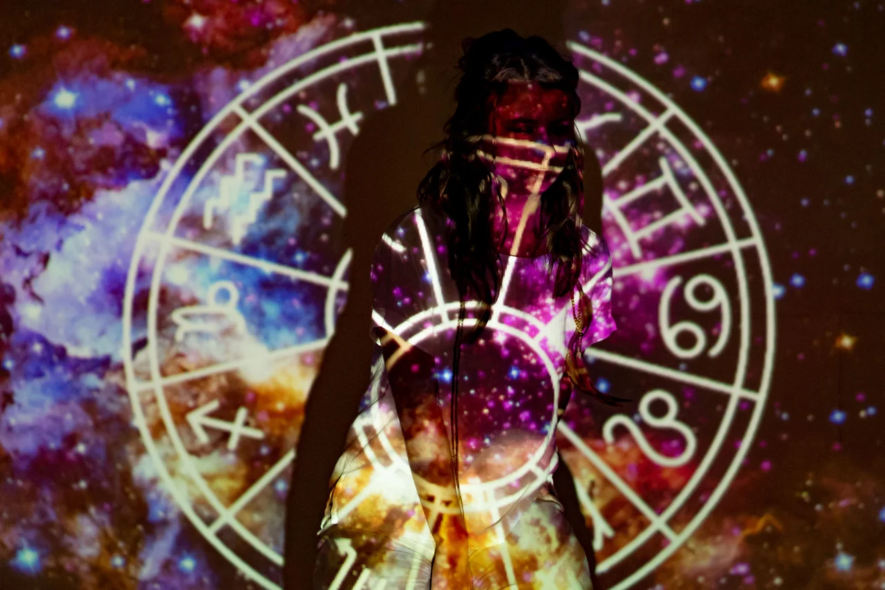 Kobieta w projekcji nieba z symbolami astrologicznymi, ilustracja żywiołów i znaków zodiaku